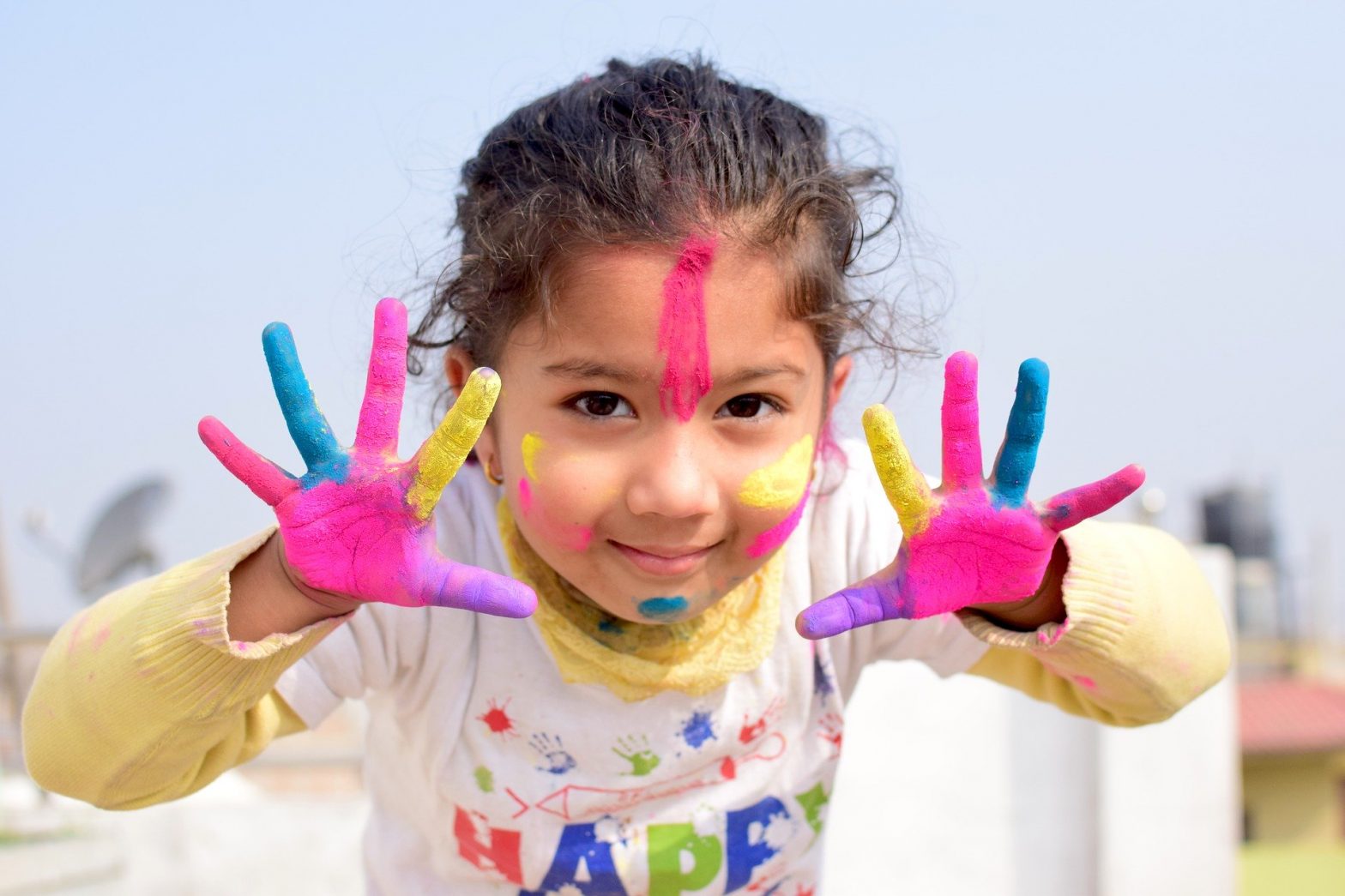 Child in a childcare center who has been finger-painting as part of a flex scheduling program
