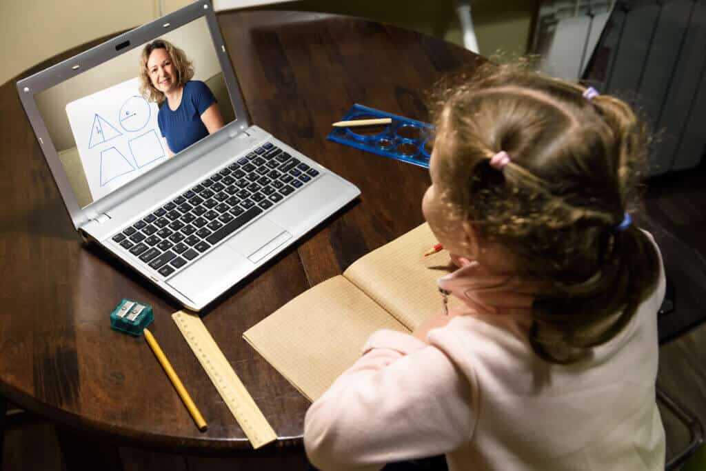 Kid virtual learning with teacher by laptop, tutor teaches preschool child during quarantine due to coronavirus.